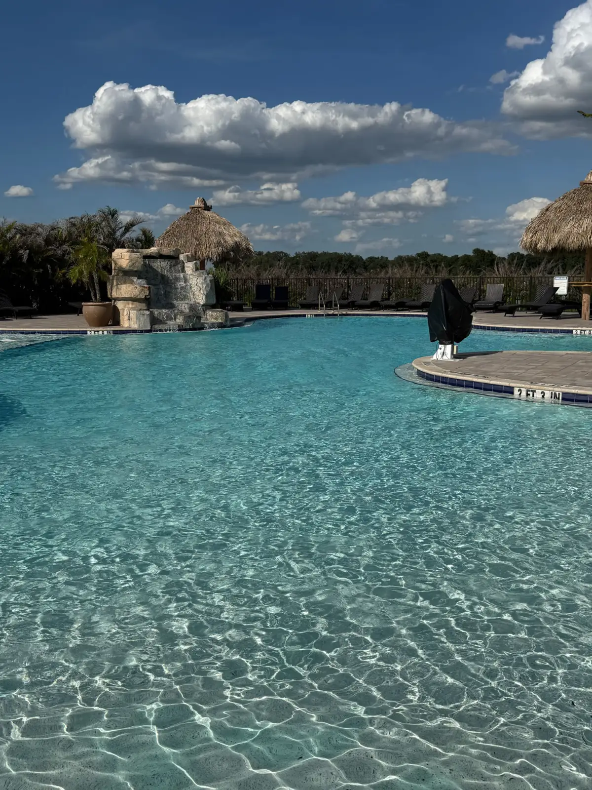 Commercial community pool with waterfall feature maintained by Tif's Pool Care in Southwest Florida